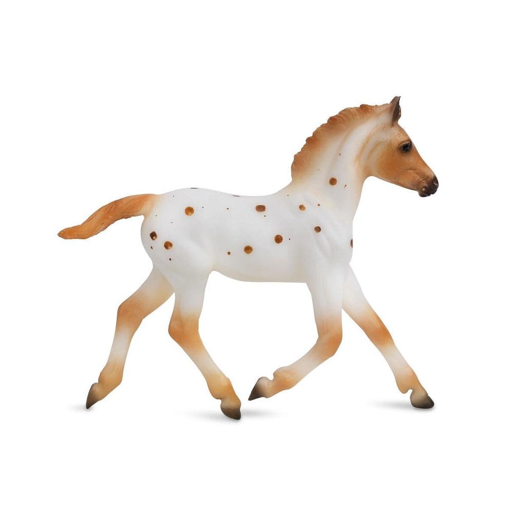 Image of the foal figurine. It is almost completely wihte with sienna colored spots, legs, face, and hair.