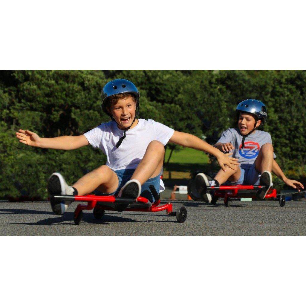 another image of two kids playing on ezrollers, the child in front has his arms stretches out, balancing himself as he rolls around