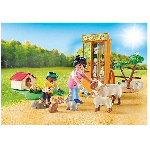 This image shows a mother geeding a sheep while a child is feeding some rabbits at the petting zoo