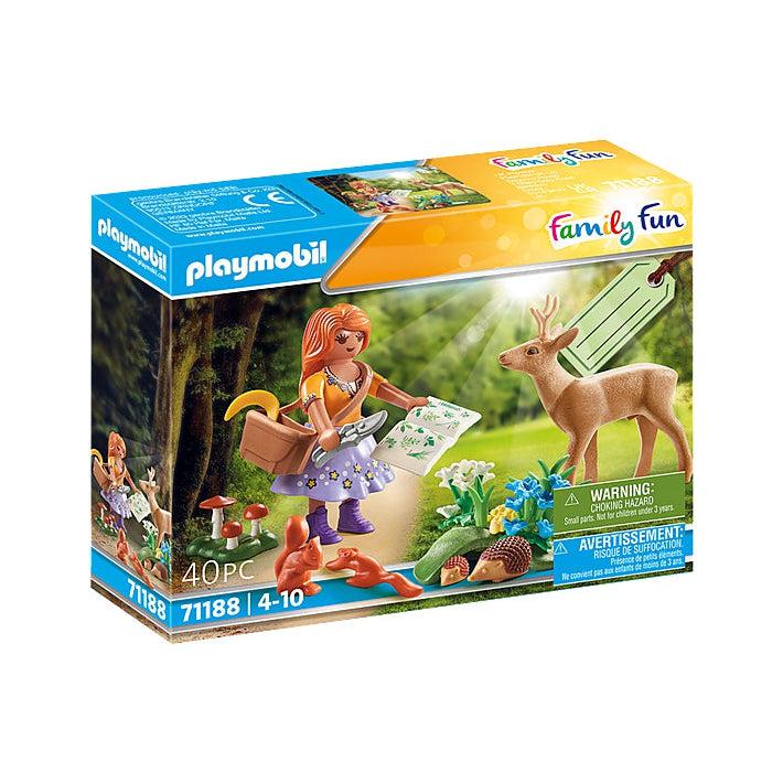 Playmobil playn scientest shows a woman walking through a forest part looking at various plants and flowers, with some mushrooms as well in the mix. there are alimals about as well like a deer and hedgehogs. 