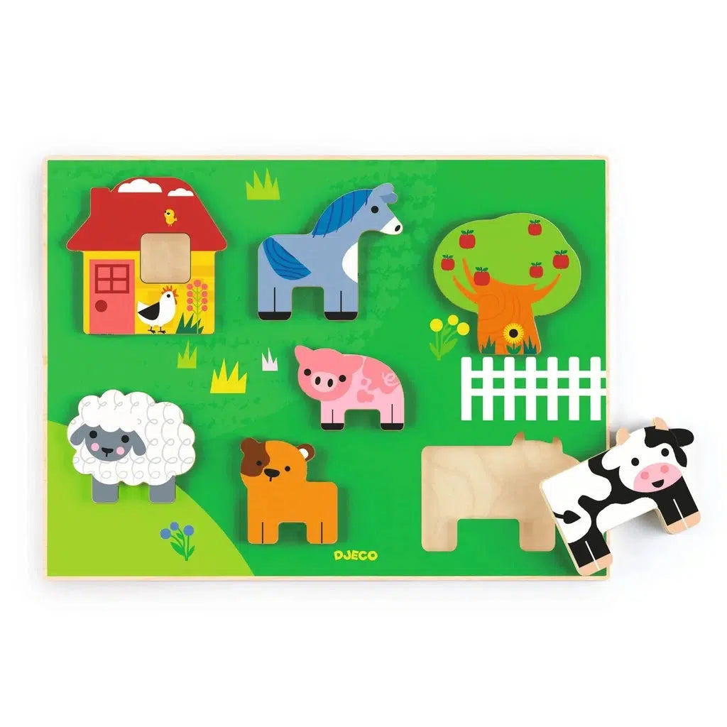 Image of the wooden puzzle board. It is a farm scene with wooden puzzle farm animal pieces.