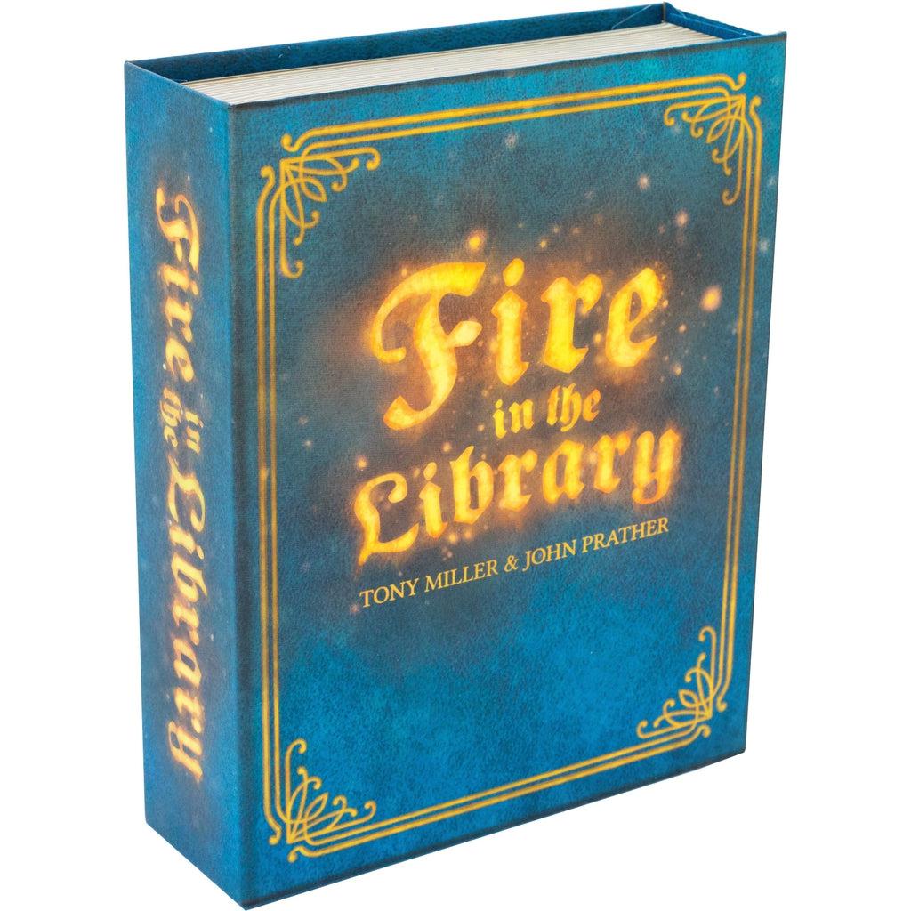 Image of the box for the game Fire in the Library. The box is uniquely shaped as a book with the name of the game acting as the title of the book. The book is blue with orange writing.