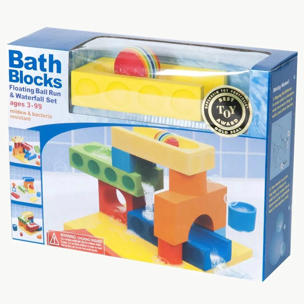 Image of the packaging for the Floating Ball Run & Waterfall Set Bath Blocks. On the front is a picture of a possible creation from the included pieces. Part of the front and top of the box is made from clear plastic so you can see the ball inside and one of the ball run pieces. The ball is mostly red with rainbow lines in the center.
