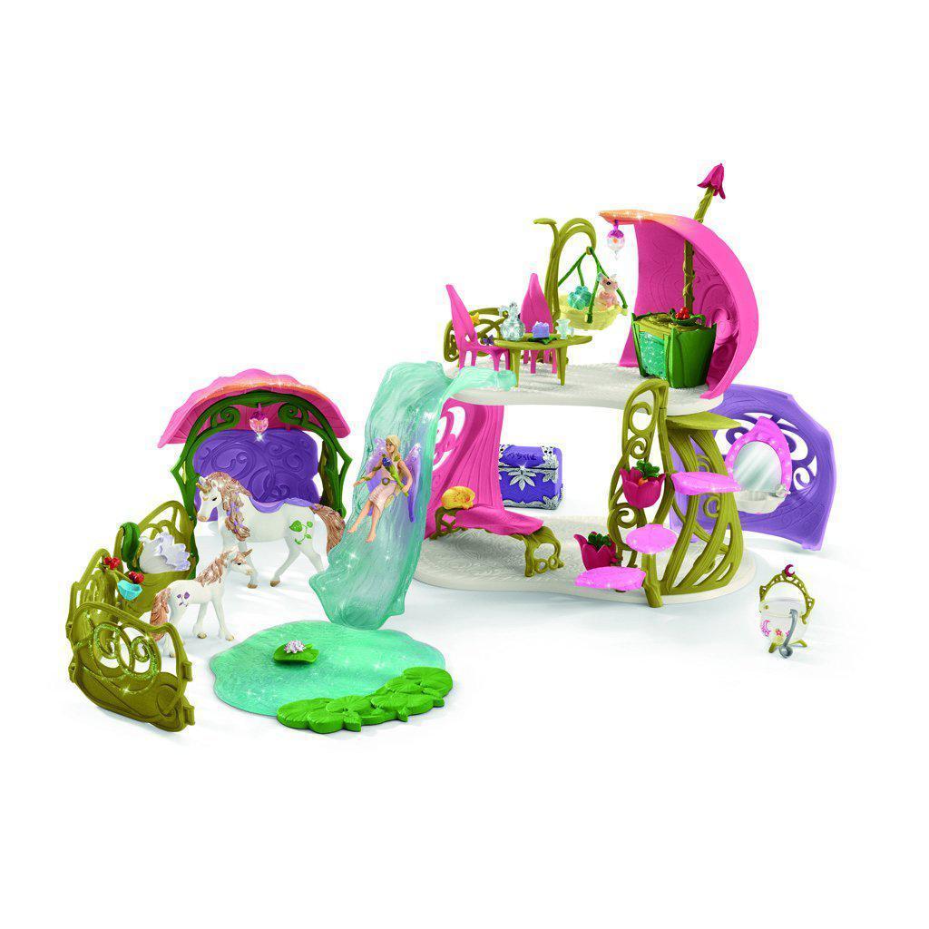 Image of the Flower House with Lake and Stable play set. It comes with a pink fairy house with a waterfall slide that leads down to a lake. It comes with a fairy and two unicorns.