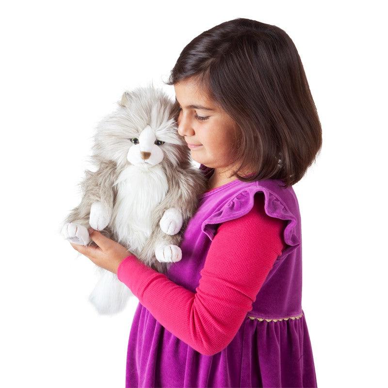 Young girl holding cat puppet on one hand and supporting it with the other.