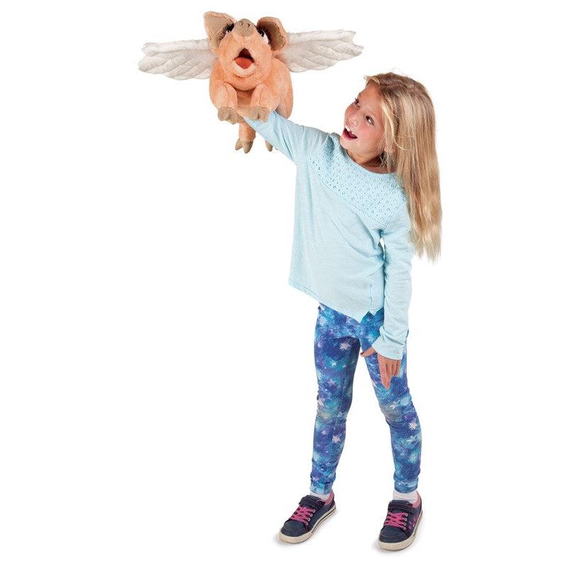 Young girl with puppet on hand making it "fly".