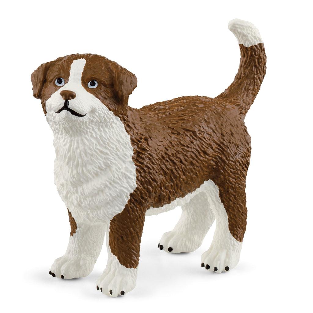 Close up of one of the dog figurines. It is a brown and white dog with a medium sized tail.