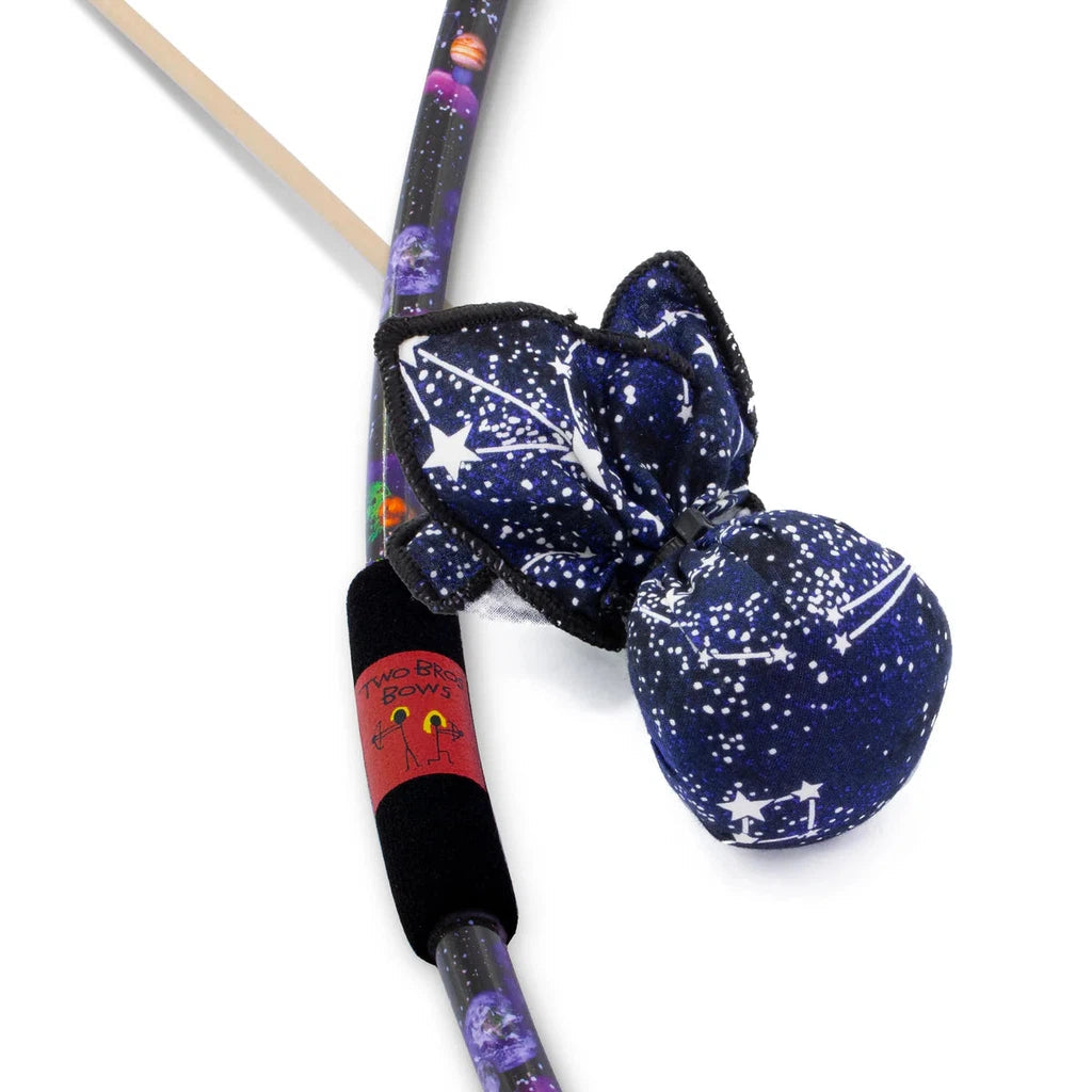 a bow with a galaxy pattern and foam grip next to an arrow with a large soft rounded constellation patterned tip