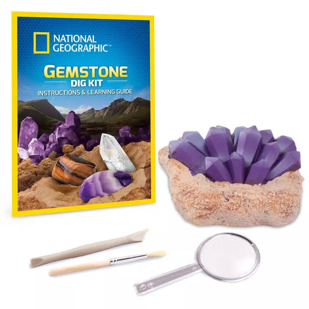 this image shows the excavation area to dig up three gems inside, with the chisel and brush, as well as the magnifying glass and the national geographic gemstone learning guide. 