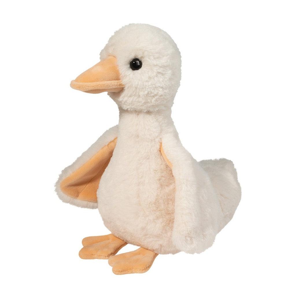 this image shows a cream colored duck with orange webbed feet and an orange beak. the duck is small and fluffy.