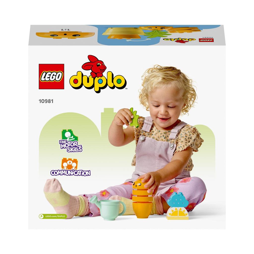Image of the back of the box. It has a scene of a little girl playing with the LEGO playset. Shows that she is developing motor skills and communication skills.