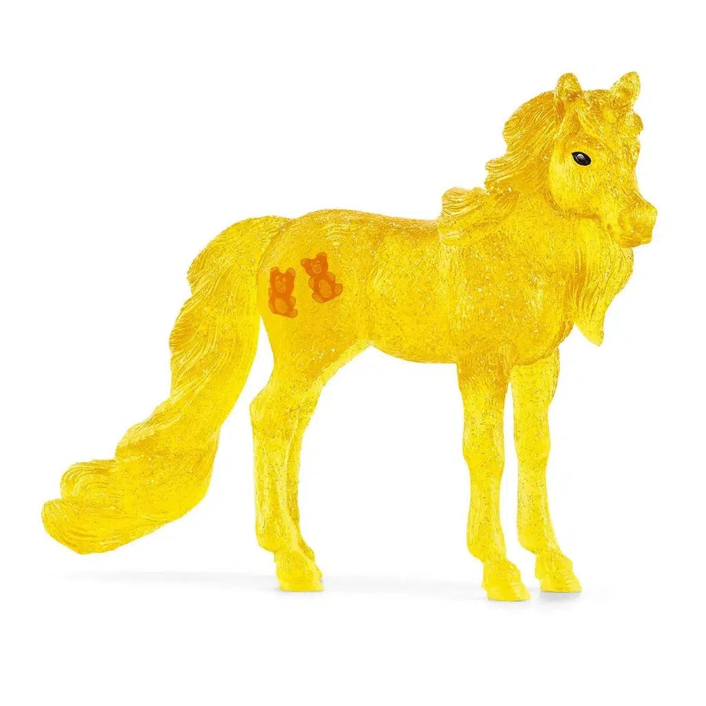 Image of the Gumdrop Horse figurine. It is a see-through yellow horse with a cutie mark of two orange gummy bears on its flank.
