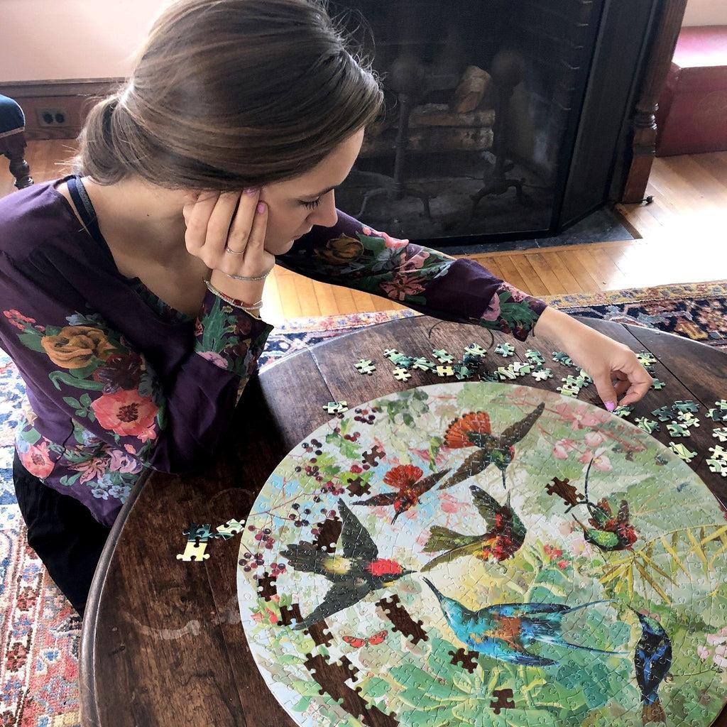 image of someone putting the puzzle together on a table, working hard after the round circle has been filled in. 
