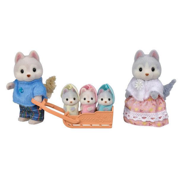 Image of the figurines outside of the packaging. It comes with a mom husky, a dad husky, and three tiny baby triplet huskys. They are all wearing old-fashioned warm winter clothing.