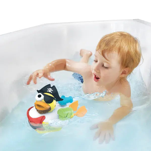 Scene of a little boy smiling while watching his creation swim with him in the bath.