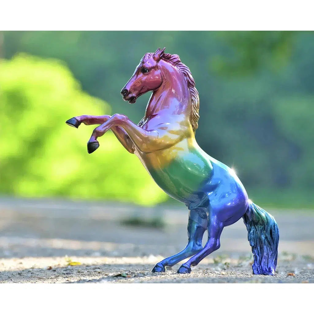 Image of the Jewels Fall 2022 Collectible figurine. It is a shiny horse figurine that starts with pink on its head and has an ombre through the rainbow until its blue tail.