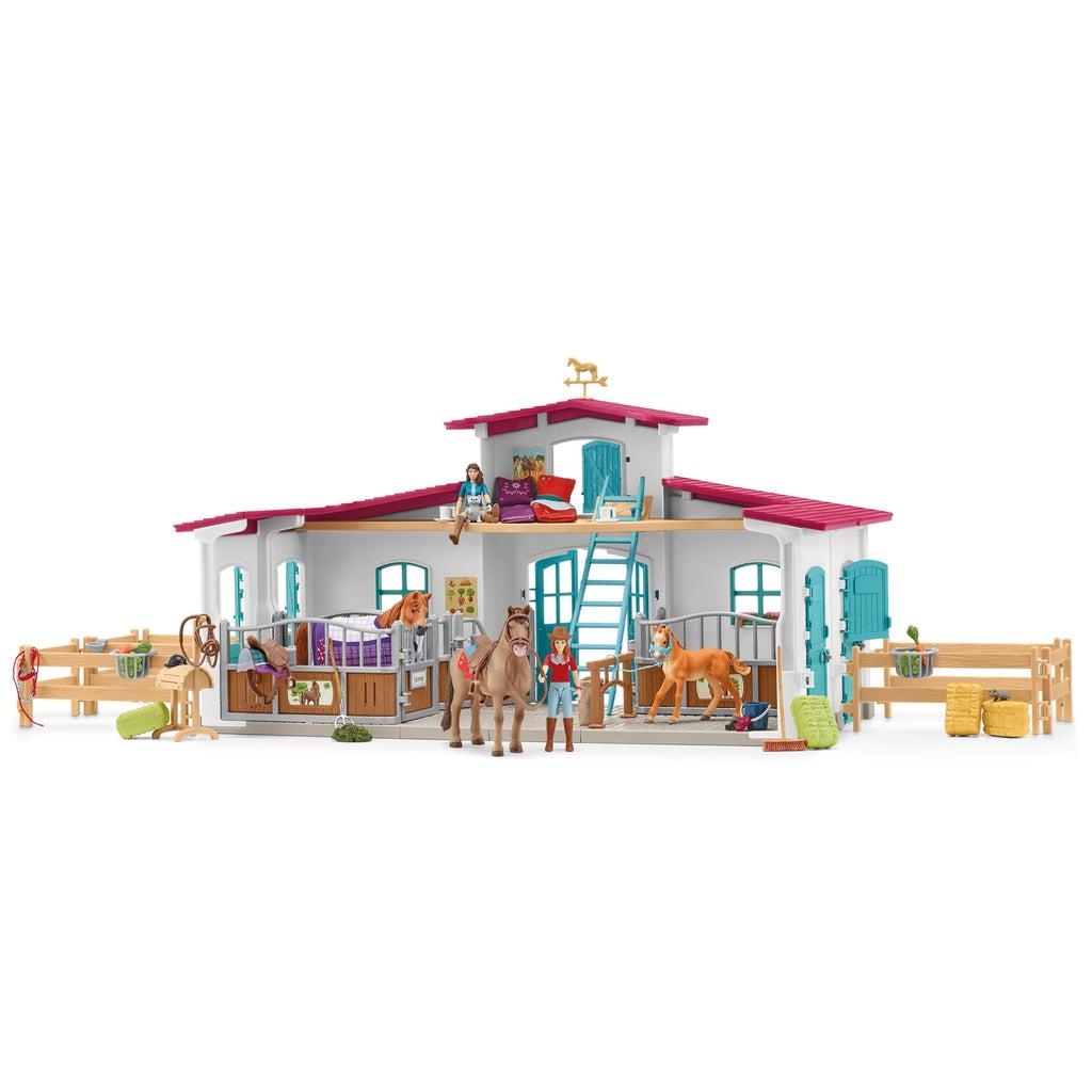 Image of the play set outside of the packaging. It comes with a riding center with fences and stables with items to take care of the horses.