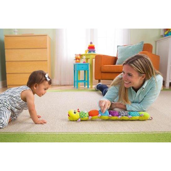 Image of a mom helping her baby learn to crawl toward to toy.