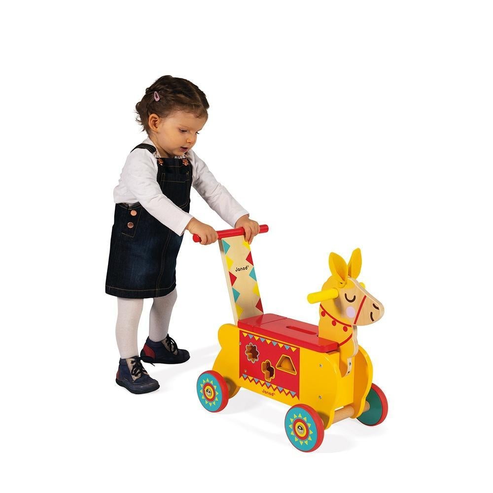 Scene of a little girl holding onto the walker portion of the toy.