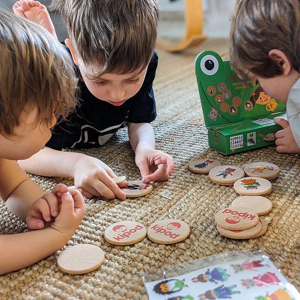 Children playing with Kipod's "Make & Match"

One child can be seen applying a design onto one of the game's wooden tokens.