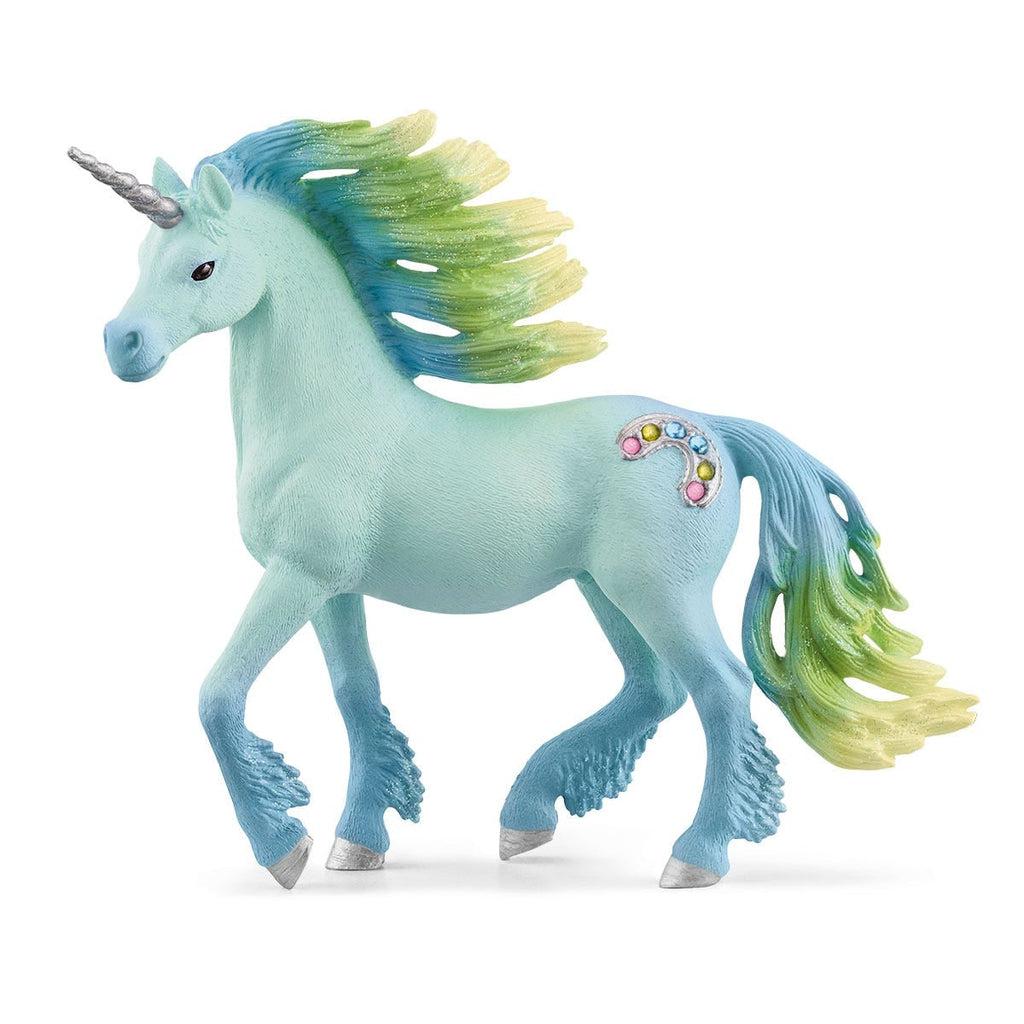 Image of the Marshmallow Unicorn Stallion figurine. It is a light blue unicorn with yellow, green, and blue mane and tail. She has a silver horn and a jewel encrusted rainbow cutie mark.