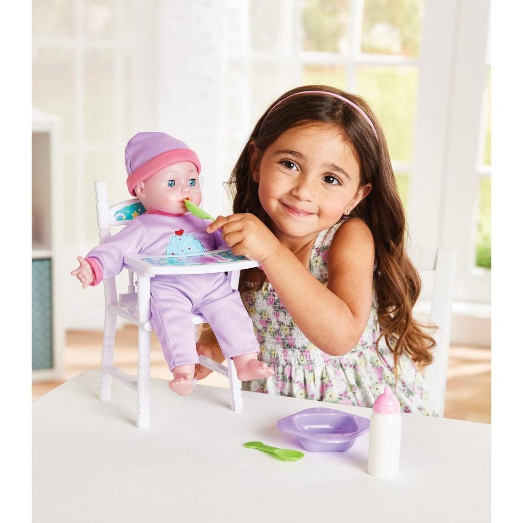 a girl is holding a plastic spoon up to the baby in the high chair, pretending to feed and care for the baby doll.