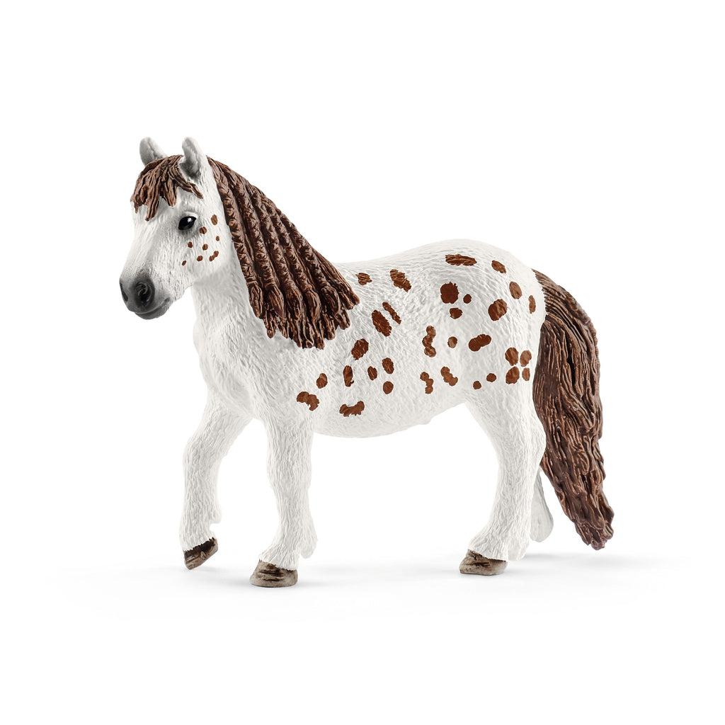 Close up of the pony figure. It is white with many small brown spots. Its mane and tail are brown and braided.