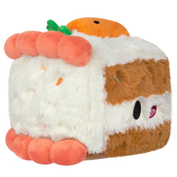 Side view of the plush. Shows that there are tiny embroidered carrots hidden in the white icing. It also has thicky poofy orange icing on the top and bottom edge.