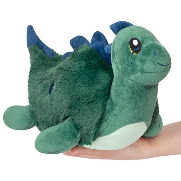 Image of the Mini Nessie squishable. It is a forest green color with blue ridges on its back.