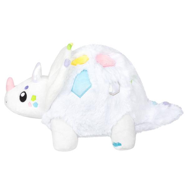 Side view of the plush. Shows the front-most horn is light pink and its toes are ble.