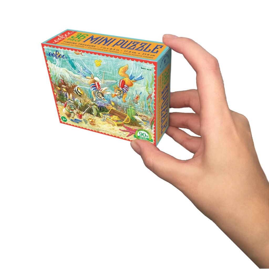 image shows the finding treasure mini puzzle in a box that can easily fit in one hand. squirrels are diving down looking for some underwater treasure!