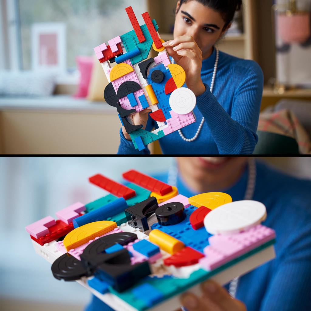 image shows a woman building the modern art LEGO set