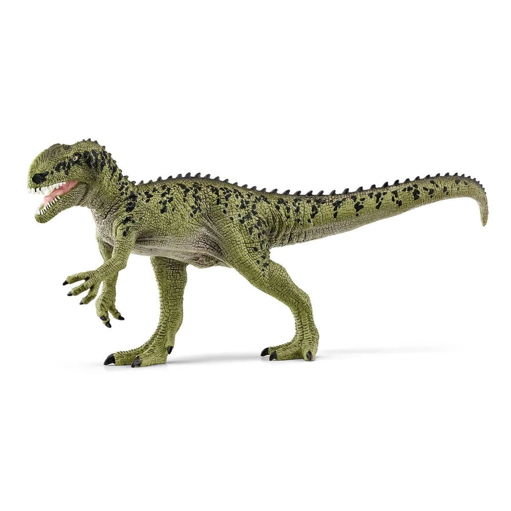 Image of the Monolophosaurus figurine. It is a smaller green dinosaur with lots of small black spots. It runs on two legs and it has sharp teeth and claws.
