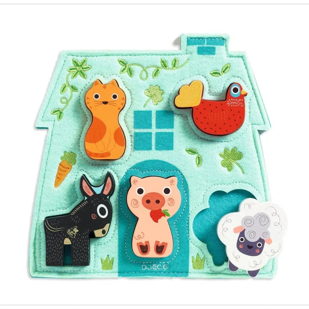 Image of the felt and wooden puzzle board. The background is a felt blue house and it has wooden animal puzzle pieces that fit on top.