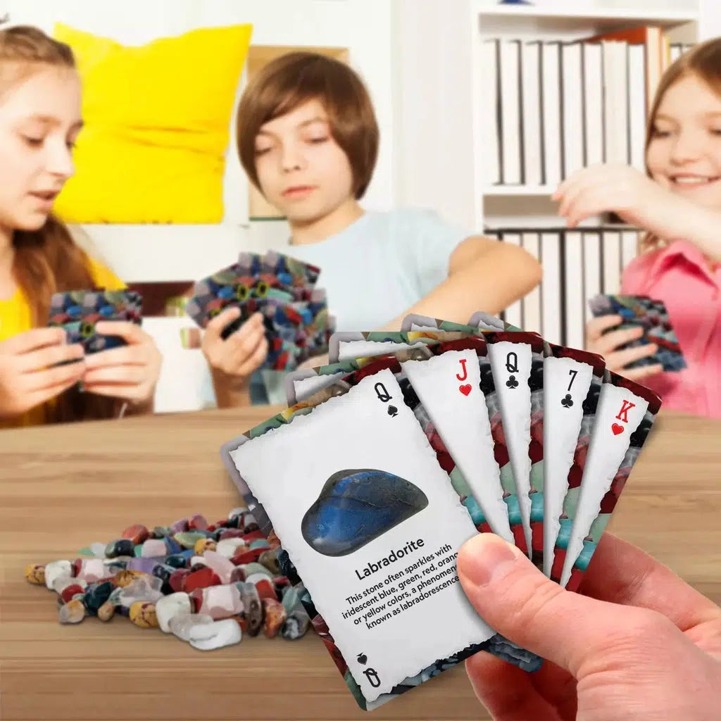 4 people are playing cards, with a pile of minerals in the center of the table