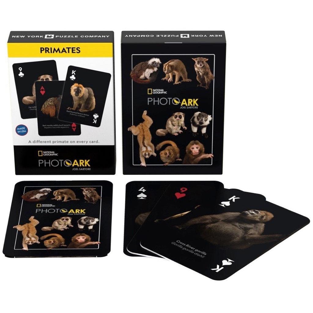 Image of the box, the back of the deck of cards, and the faces of three different example cards. Each card has a black background to emphasize the pictures of primates.