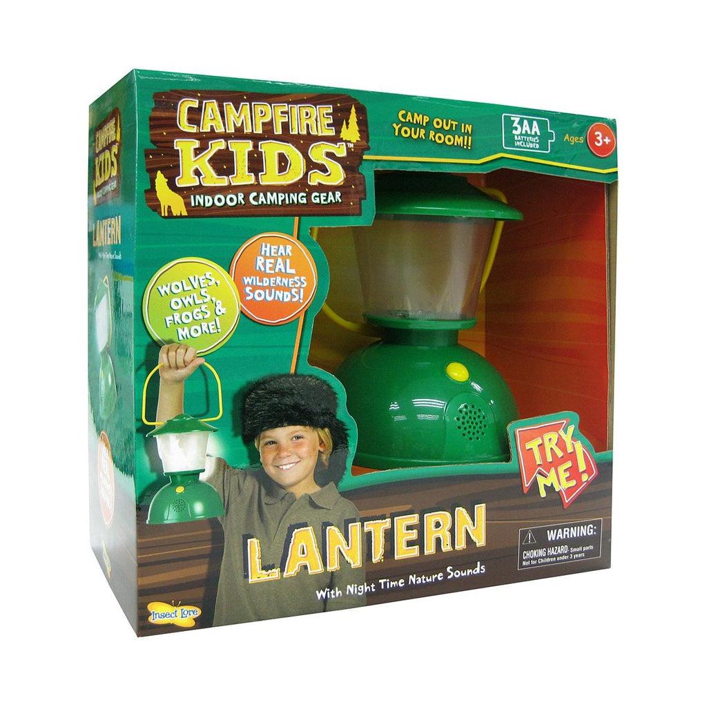 Image of the packaging for the Lantern toy. Part of the front of the box is cut away so you can see and touch the toy inside. The lantern is mainly made out of green plastic with a yellow handle. It has a speaker on the front and a yellow button that turns the lantern on/off.