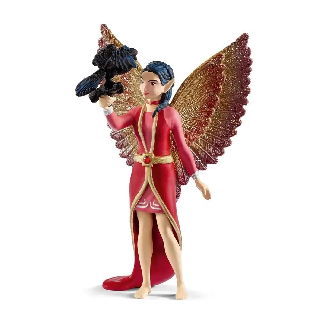 Image of the Nuray with Munyn the Raven figurines. She is wearing a short in front, long in back red and gold dress that matches her wings. On one arm she is holding a detachable black raven.