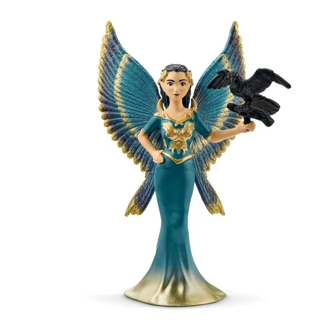 Image of the figurine outside of the packaging. She is wearing a turquoise and gold gown that matches her large wings. On her arm is a black raven.