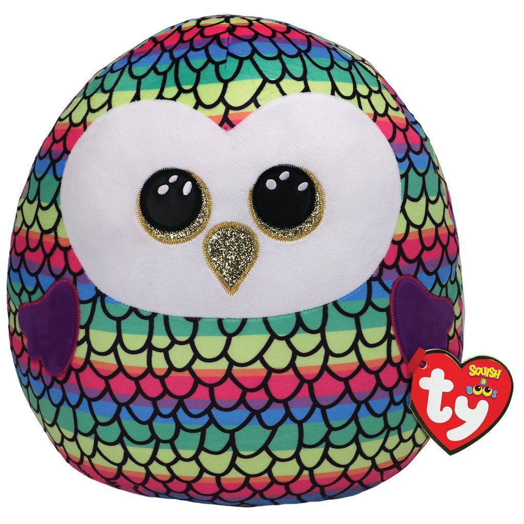 Image of the Owen Rainbow Owl Squish-A-Boo plush. It is a rainbow striped plush with a black feather pattern on top. It has glittery golden eyes and beak.