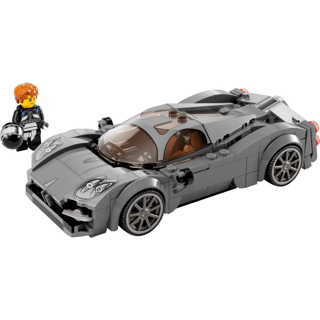 minifigure shown standing next to the lego car and holding a race car drivers helmet