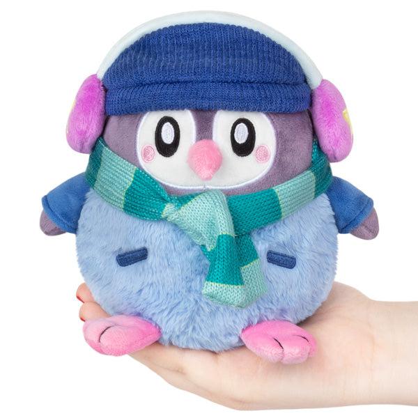 Small plush penguin, blue with adorable face, wearing a blue winter hat and scarf