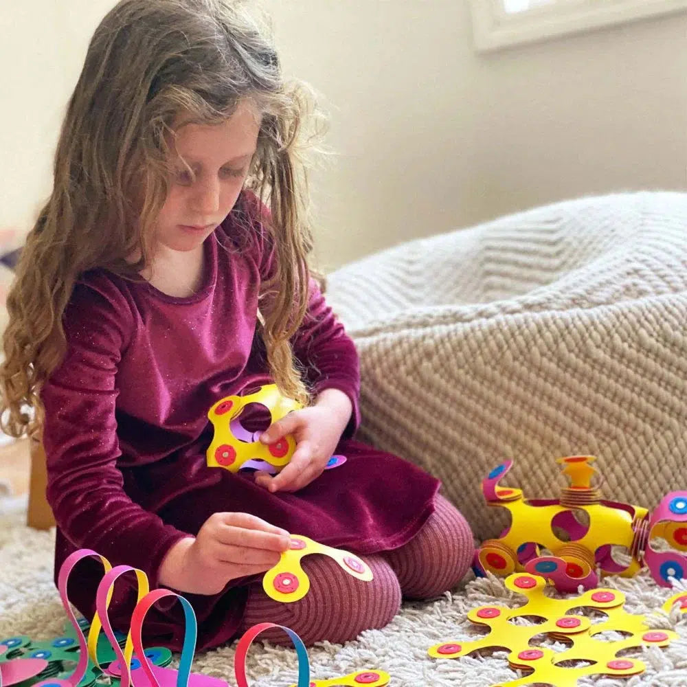 image shows a girl playing with Clixo magnetic building toys