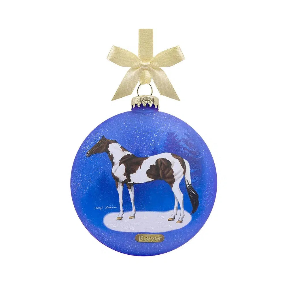A blue circular ornament with a black and white spotted Pinto horse.