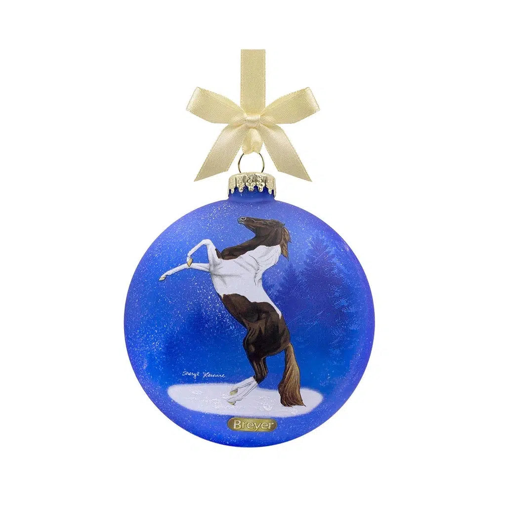 A blue circular ornament with a black and white spotted Pinto horse. The horse is rearing up