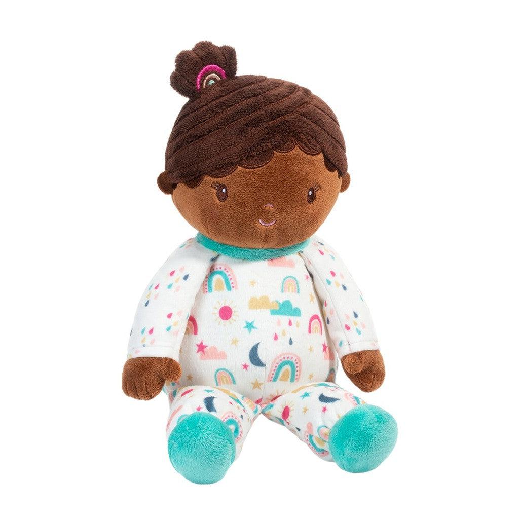 this image shows a baby doll who has a rainbow bow in her hair and pajamas that have rainbows and clouds and the sun on them!