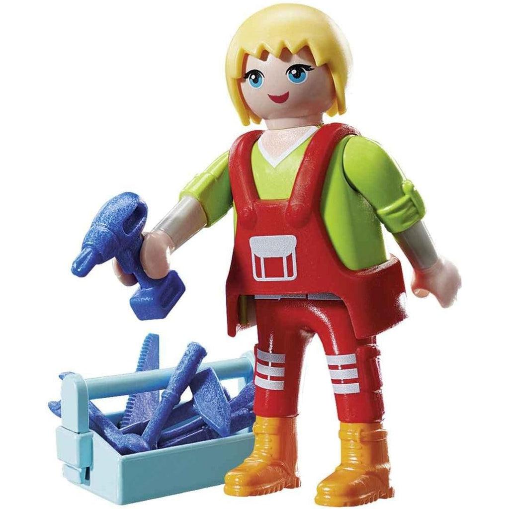 This image shows the maintanence girl with her tools on the ground, but she is holding a drill and ready to work. 