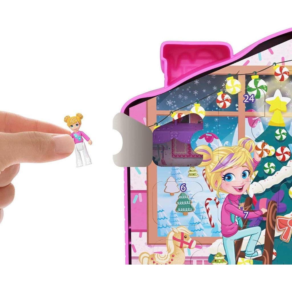 one of the polly pockets is shown being removed from one of the door tabs on the calendar.