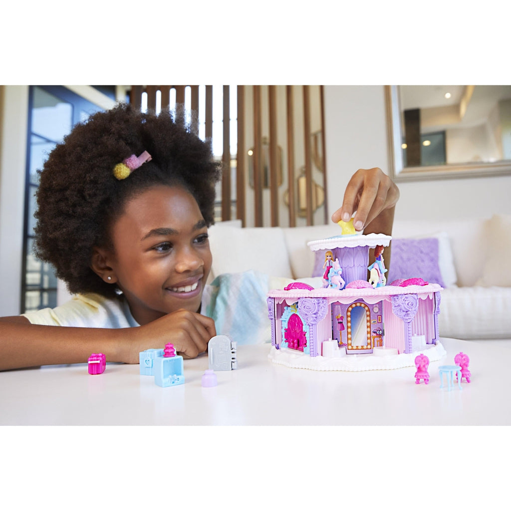 Scene of a little girl smiling while playing with her Polly Pocket playset.