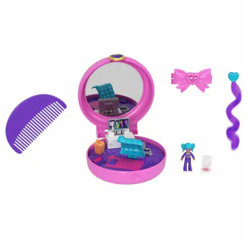Image of all the included pieces. The set includes a compact with play area inside, a comb, a clip, a hair extension, and a Polly Pocket with blue hair.